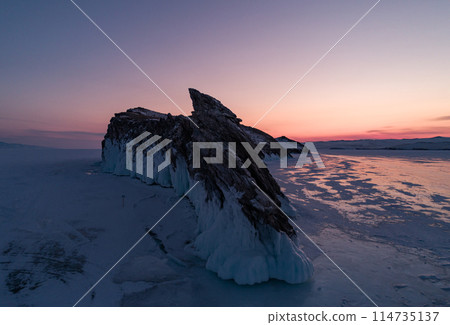 Ogoy island on winter Baikal lake. Winter scenery of Dragon Tail Rock on Ogoy island during sunrise at Lake Baikal. Ogoy island on winter Baikal lake. Winter scenery of Dragon Tail Rock on Ogoy island during sunrise at Lake Baikal. 114735137