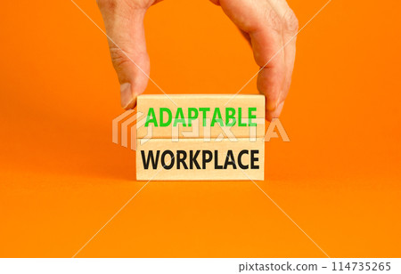 Adaptable workplace symbol. Concept words Adaptable workplace on beautiful wooden block. Beautiful orange paper background. Businessman hand. Business Adaptable workplace concept. Copy space. 114735265
