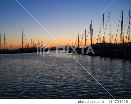 Sunset in Italy Sardinia. Serene evening in Sardinia's Alghero, where the sun dips below the horizon, casting a warm, golden glow across the tranquil waters of the Mediterran Sea. Sunset in Italy Sardinia. Serene evening in Sardinia's Alghero, where the sun dips below the horizon, casting a warm, golden glow across the tranquil waters of the Mediterran Sea. 114735436