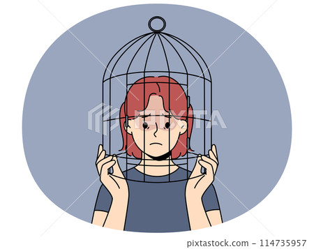 Unhappy teen girl with head in birdcage 114735957