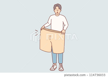 Lost weight man with big shorts in hands is surprised at size of own clothes from past 114736033