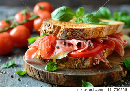 Sandwich with prosciutto, tomato and cheese on a wooden rustic background. Sandwich with prosciutto, tomato and cheese on a wooden rustic background. 114736236