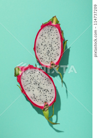 Two half of dragon fruit on blue background, top view 114737209