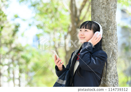 High school girl listening to music headphones 114739312