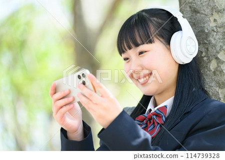 High school girl listening to music headphones 114739328