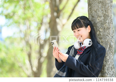 High school girl with smartphone, headphones High school girl with smartphone, headphones 114739338