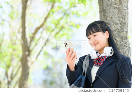High school girl with smartphone, headphones 114739343