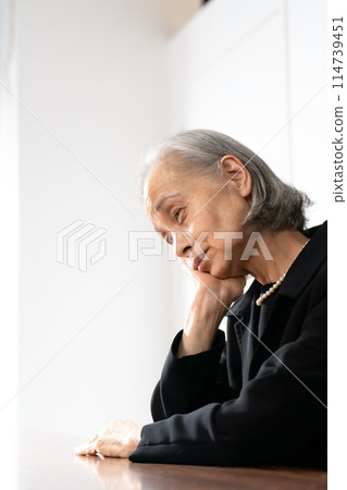 Senior woman in mourning clothes worries 114739451