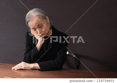 穿著喪服的老婦人，孤獨而憂心忡忡 114739455