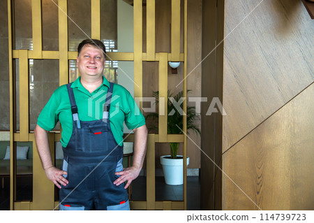 Working man in green T-shirt and blue overalls Working man in green T-shirt and blue overalls 114739723