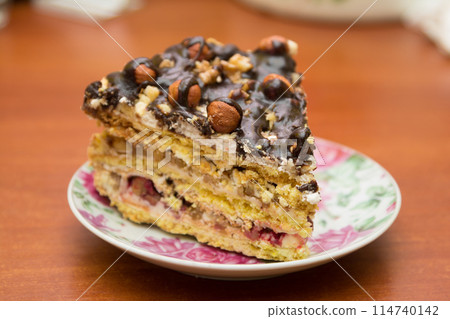 Piece of cake with hazelnuts and chocolate - in a saucer Piece of cake with hazelnuts and chocolate - in a saucer 114740142