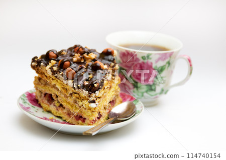 Piece of cake with hazelnuts, teaspoon and cup Piece of cake with hazelnuts, teaspoon and cup 114740154