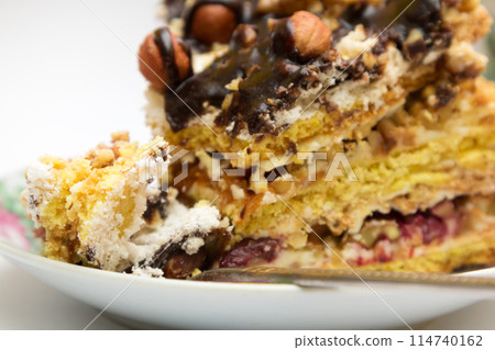 Piece of cake with hazelnuts and chocolate in a saucer 114740162