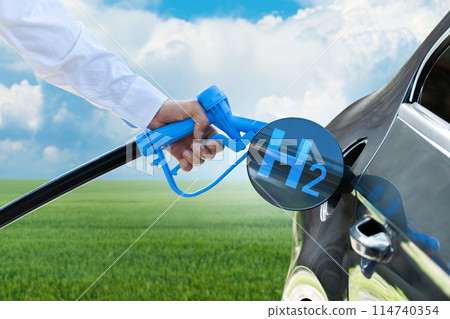 Man holds a hydrogen fueling nozzle. Refueling car with hydrogen fuel. Concept Man holds a hydrogen fueling nozzle. Refueling car with hydrogen fuel. Concept 114740354