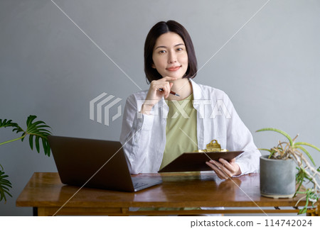 年輕女子在房間裡操作電腦 年輕女子在房間裡操作電腦 114742024