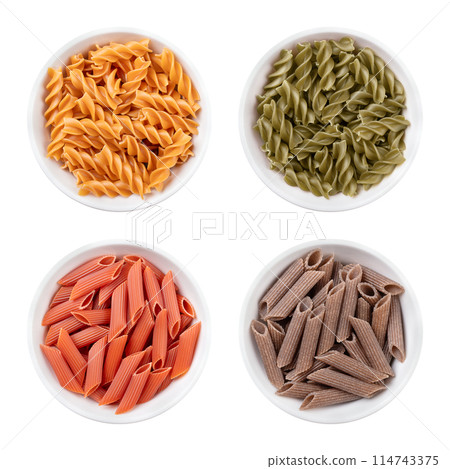 Fusilli and penne, gluten-free pasta, noodles made without wheat flour, in white bowls. Above yellow chickpea fusilli and green pea fusilli, below red lentil penne and brown buckwheat penne. 114743375