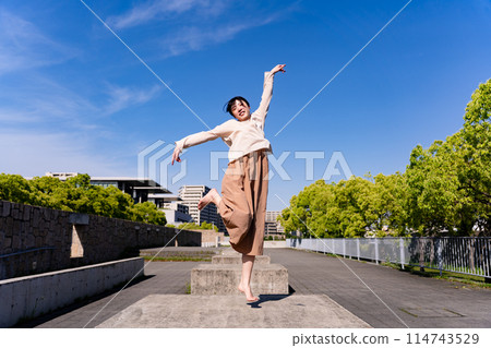 Woman jumping in the park Woman jumping in the park 114743529