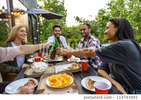 Young people enjoying leisure time together outside toasting with beer 114743891