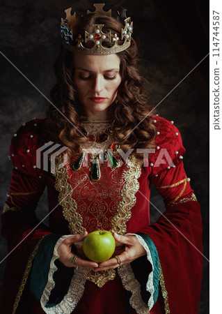 medieval queen in red dress with green apple and crown medieval queen in red dress with green apple and crown 114744587