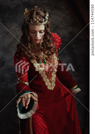 medieval queen in red dress with crown making reverence medieval queen in red dress with crown making reverence 114744590