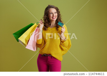 happy fit woman in yellow sweater isolated on green happy fit woman in yellow sweater isolated on green 114744611