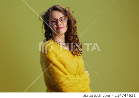 smiling woman in sweater and glasses against green 114744621