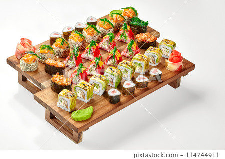Set of assorted Japanese sushi rolls and gunkan maki on wooden tray 114744911