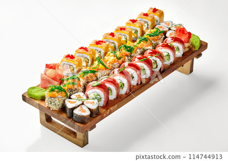 Delicious set of assorted sushi rolls on wooden tray Delicious set of assorted sushi rolls on wooden tray 114744913