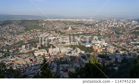 Wide angle view of beautiful city if Tbilisi and Kura river from Mount Mtatsminda with Holy Trinity Cathedral in the center and Old Town on the right side Wide angle view of beautiful city if Tbilisi and Kura river from Mount Mtatsminda with Holy Trinity Cathedral in the center and Old Town on the right side 114745216