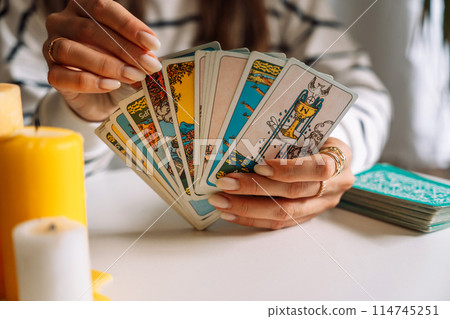 Lady tarot reader pulls a tarot card from the deck Lady tarot reader pulls a tarot card from the deck 114745251