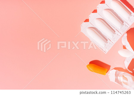 Rectal candles in packaging and unpacked on a pink background 114745263