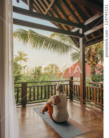 Middle aged woman practicing yoga on a balcony 114745331