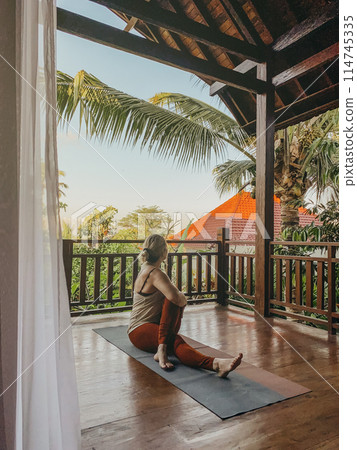 Middle aged woman practicing yoga on a balcony 114745335