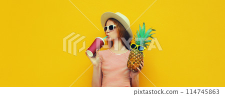 Summer portrait of stylish young woman drinking fresh juice with pineapple fruit Summer portrait of stylish young woman drinking fresh juice with pineapple fruit 114745863