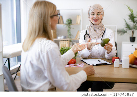 Medical specialist giving advice on improving diet by abundance of nutrients. 114745957