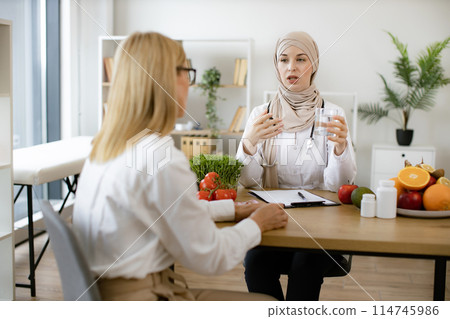 Mature female patient receives information about water balance. 114745986