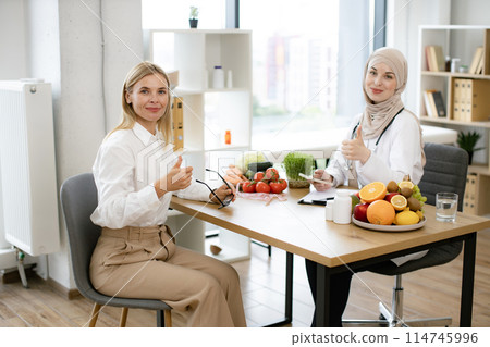 Young Arab female doctor making healthy eating plan. Young Arab female doctor making healthy eating plan. 114745996