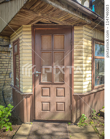 Wooden door with texture and glass insertions in renewed building Wooden door with texture and glass insertions in renewed building 114746003