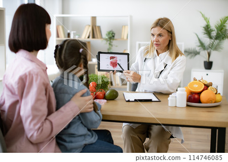 Female doctor showing tablet with gastrointestinal tract. 114746085