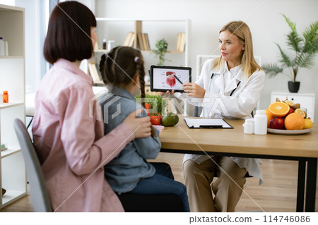 Mother with little girl at appointment with family nutritionist. Mother with little girl at appointment with family nutritionist. 114746086