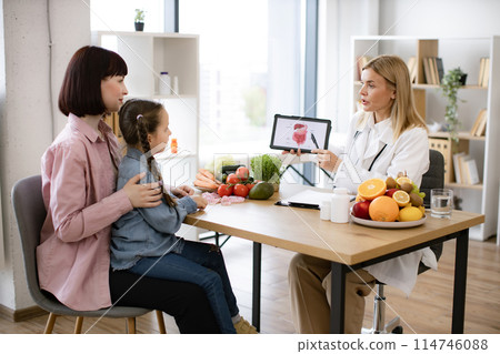 Mother with little girl at appointment with family nutritionist. 114746088