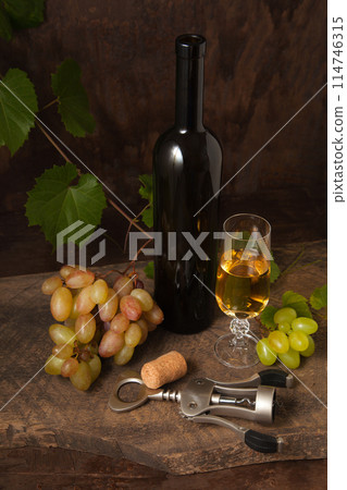 Still life with glass of white wine and grapes on vintage wooden background.. Still life with glass of white wine and grapes on vintage wooden background.. 114746315