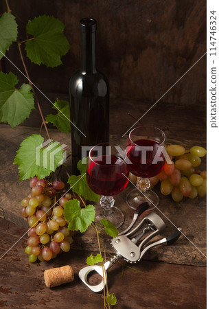 Still life with glasses of red wine and grapes on vintage wooden background.. Still life with glasses of red wine and grapes on vintage wooden background.. 114746324