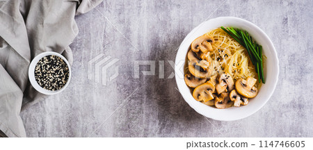 Asian soup with rice noodles, mushrooms and green onions in a bowl top view web banner Asian soup with rice noodles, mushrooms and green onions in a bowl top view web banner 114746605