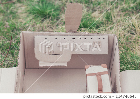 Toy cardboard plane in the field. Focus on the steering wheel 114746643