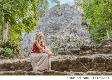 Woman tourist at Coba, Mexico. Ancient mayan city in Mexico. Coba is an archaeological area and a famous landmark of Yucatan Peninsula. Cloudy sky over a pyramid in Mexico Woman tourist at Coba, Mexico. Ancient mayan city in Mexico. Coba is an archaeological area and a famous landmark of Yucatan Peninsula. Cloudy sky over a pyramid in Mexico 114746651