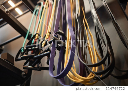 Background image of sports equipment on rack in gym with focus on resistance bands for strength training copy space 114746722