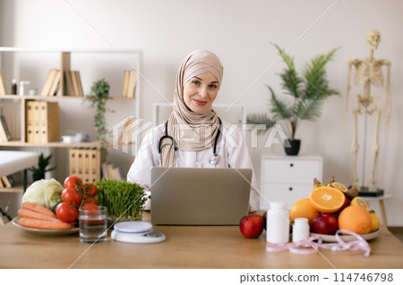 Muslim nutritionist doctor with fruits and vegetables in office. 114746798