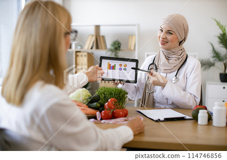 Professional nutritionist tells patient about benefits of healthy diet. 114746856