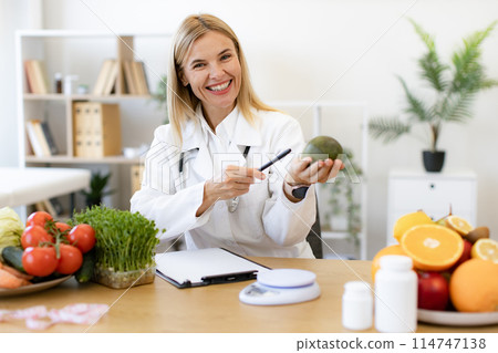 Happy female writing prescription for patients proper healthy diet. Happy female writing prescription for patients proper healthy diet. 114747138